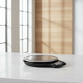 Digital kitchen scale with a clear lid on a white background