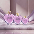 Three sizes of Vera Wang Princess perfume bottles on a dark purple background