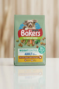 A bag of Purina Bakers Recipe Using Superfoods Weight Control Adult dog food, featuring a blue wood-textured background with a small dog, vegetables, and kibble pieces.