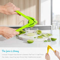 Person using a green citrus squeezer on a white plate with sliced limes and cucumbers.
