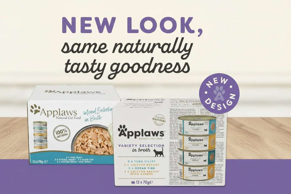 Promotional graphic for Applaws pet food showing two product boxes and a canister set on a beige and purple background with large headline text reading 'NEW LOOK, same naturally tasty goodness' and a circular 'NEW DESIGN' badge.