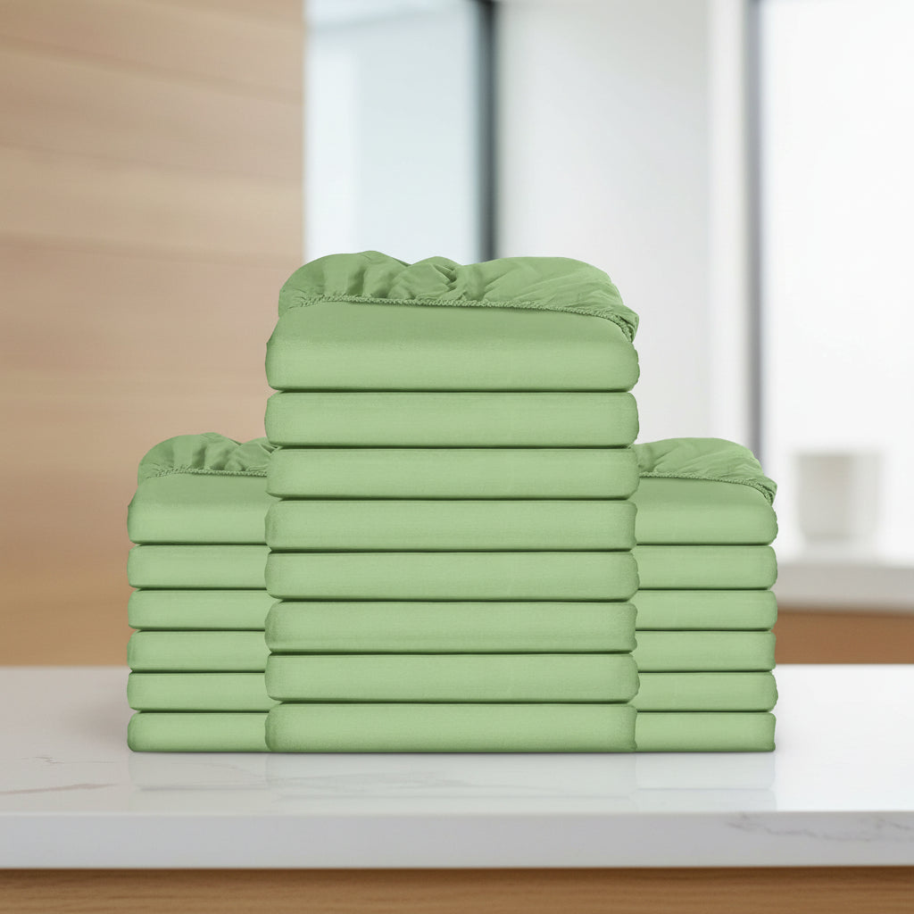 Stack of green fitted sheets on a white background