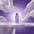 L'Oréal Paris Revitalift Anti-Ageing Serum in a clear glass bottle with a white dropper cap, set against a purple gradient background with promotional text.
