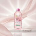 Garnier Micellar Cleansing Water bottle with pink cap on a pink background