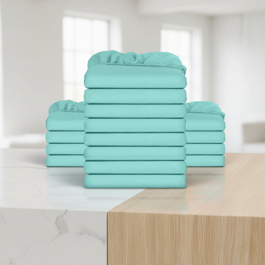 Stack of teal-colored fitted sheets on a white background