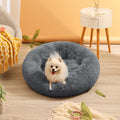 Fluffy gray pet bed with a small white dog inside in a cozy living room.