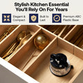 A close-up of a wooden drawer organizer filled with kitchen utensils, including gold-toned spoons and a metal tea infuser, with a black-and-silver Sharpie steaming kettle in the front compartment. Text at the top reads: 'Stylish Kitchen Essential You'll Rely On For Years' with feature callouts.