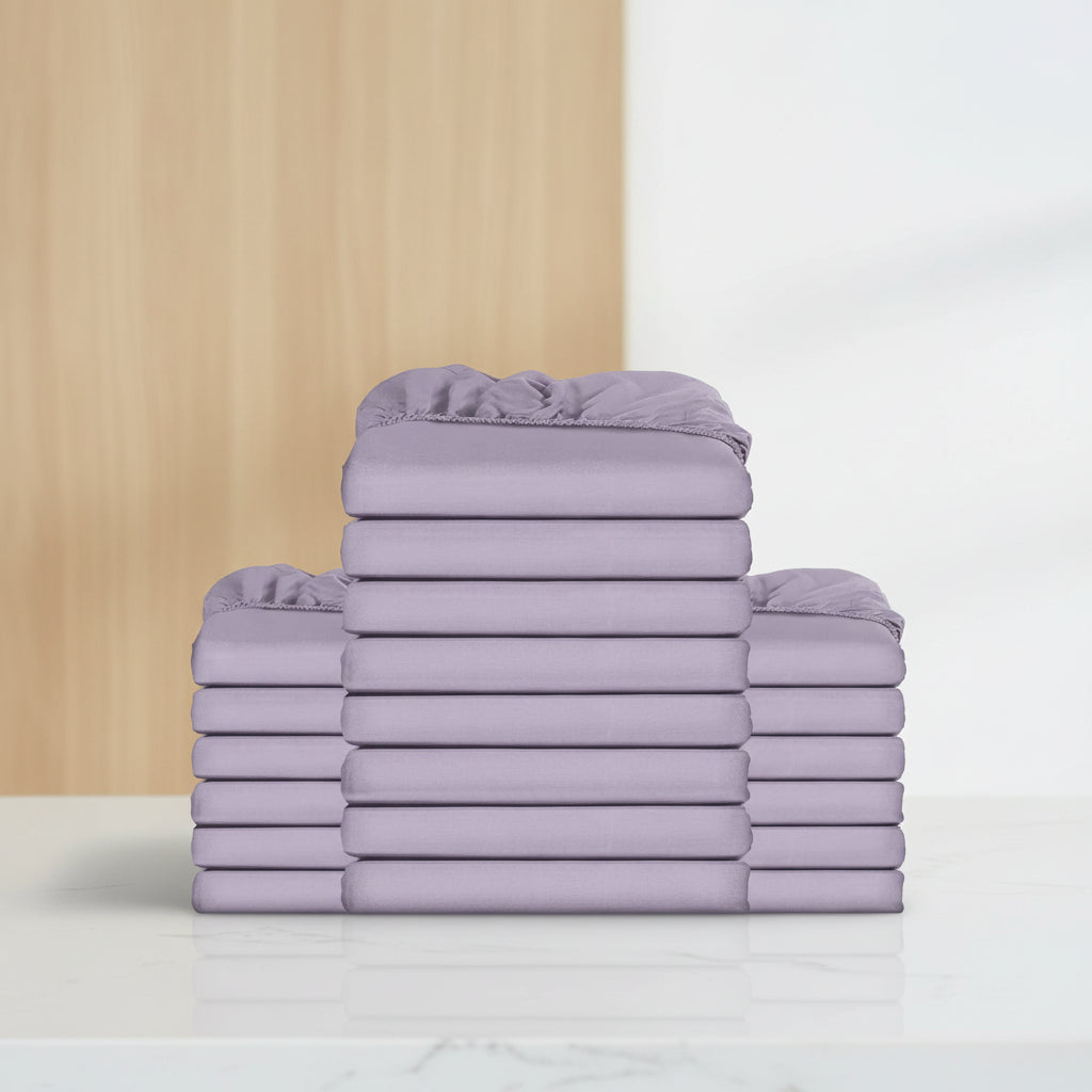 A stack of folded sheets in a solid light purple/lavender color, arranged symmetrically against a plain white background.