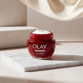 Olay Regenerist cream jar with whipped cream on a white background