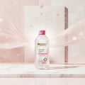 Garnier Skinactive Micellar Cleansing Water in a 400ml clear bottle with a pink cap, set against a pink textured background with text overlays.