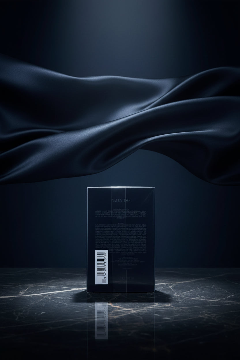 Valentino Uomo Born in Roma Extradose perfume box in dark blue packaging with pink lettering, shown in its plastic wrapping on a white background.